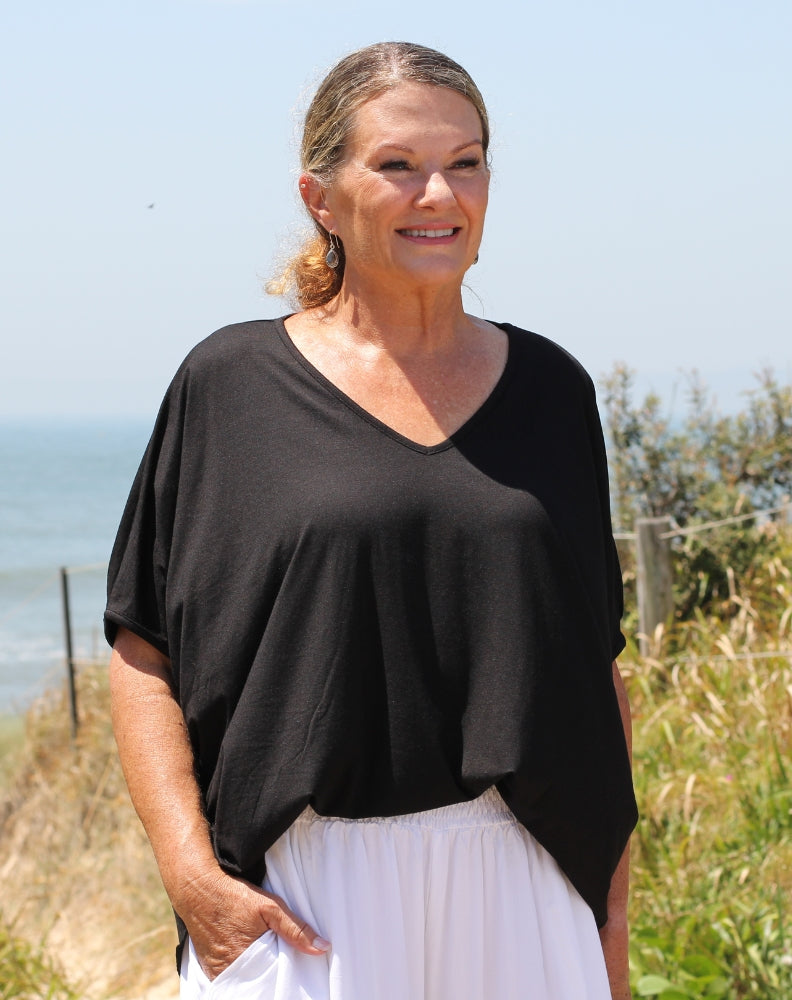 cold shoulder top in black modal worn by sizr 10 model with white everyday resort pant