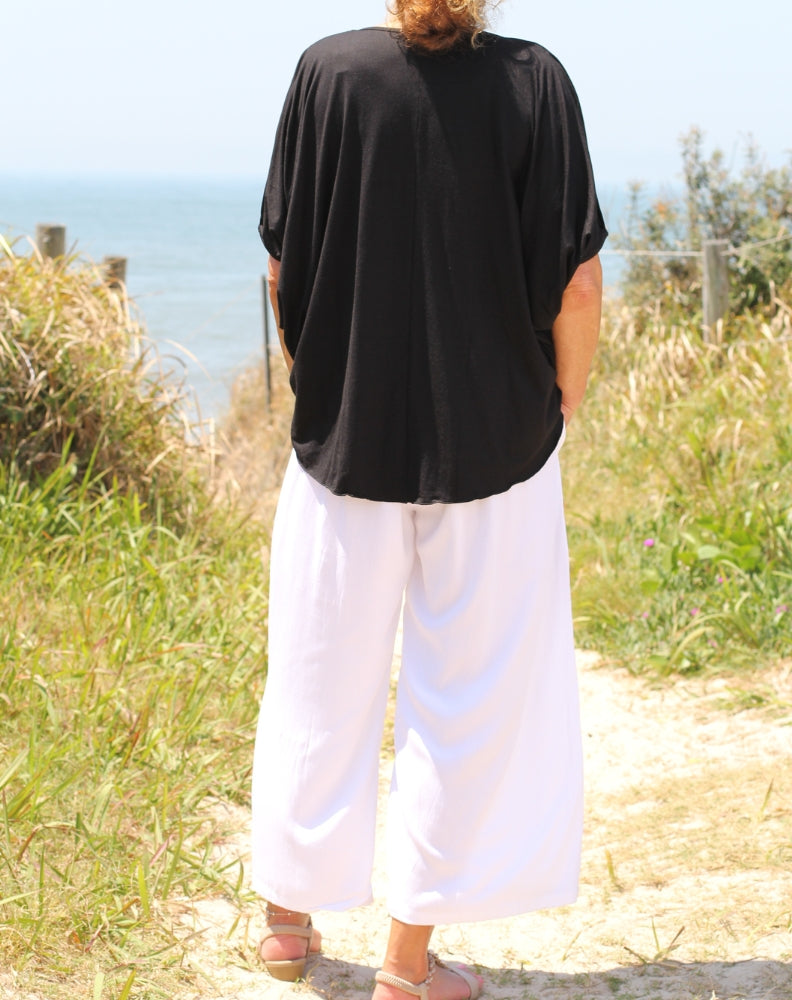 showing back of cold shoulder top in black modal worn out of pants