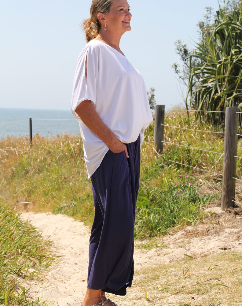cold shoulder top in white modal by miss seafari worn with navy everyday pant
