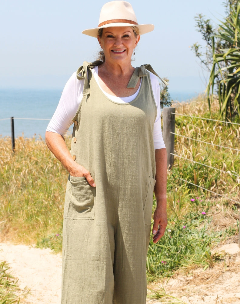 tiestrap jumpsuit in sage with adjustable shoulder straps worn with white tee for cooler weather