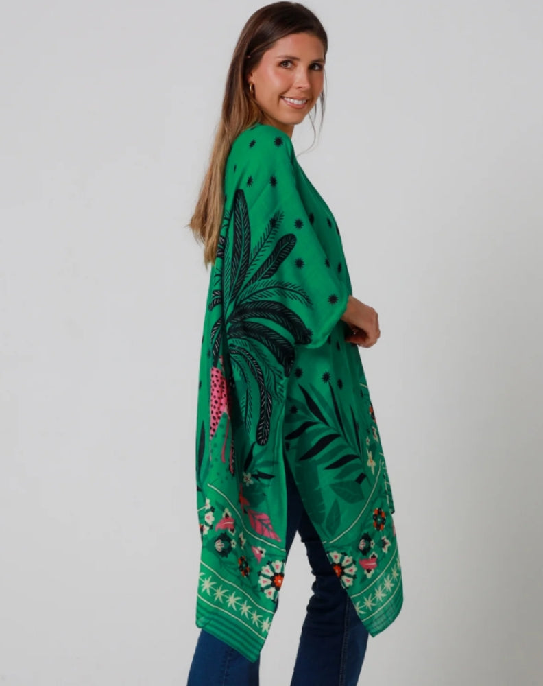 Woman wearing a green modern kimono jacket worn with jeans for a weekend look