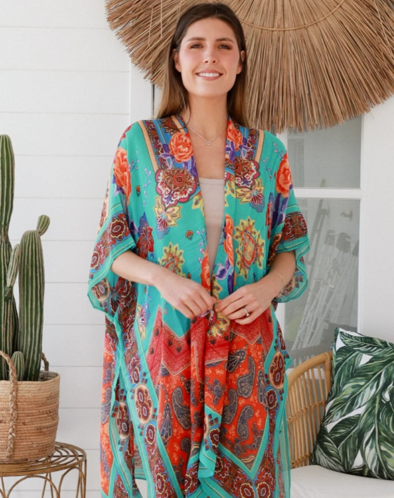 Woman wearing aqua camilla kimono standing indoors in a boho garden setting