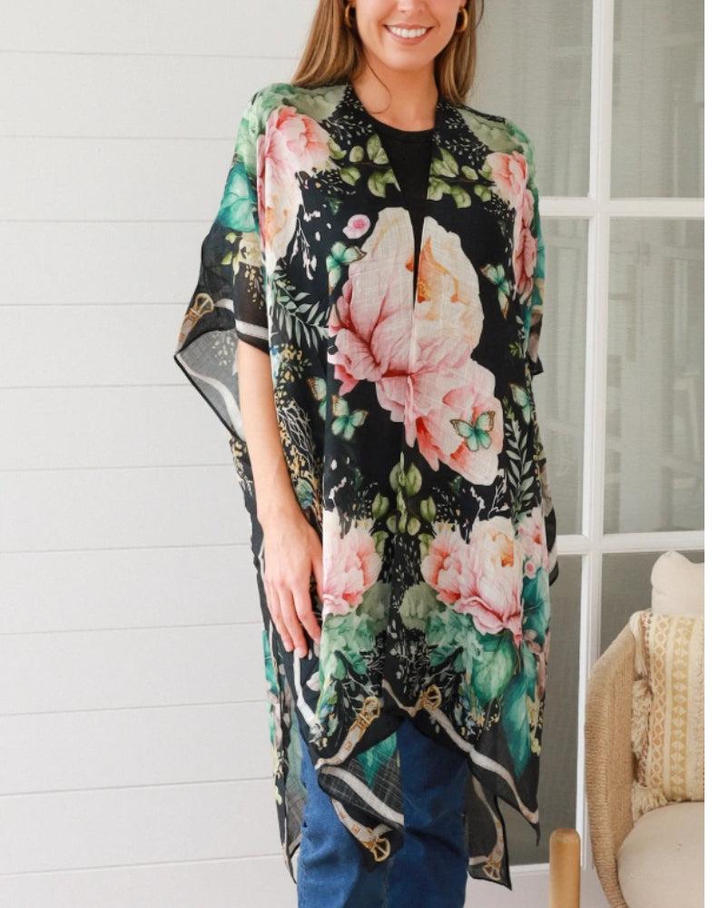 Woman wearing a floral kimono-style garment indoors.