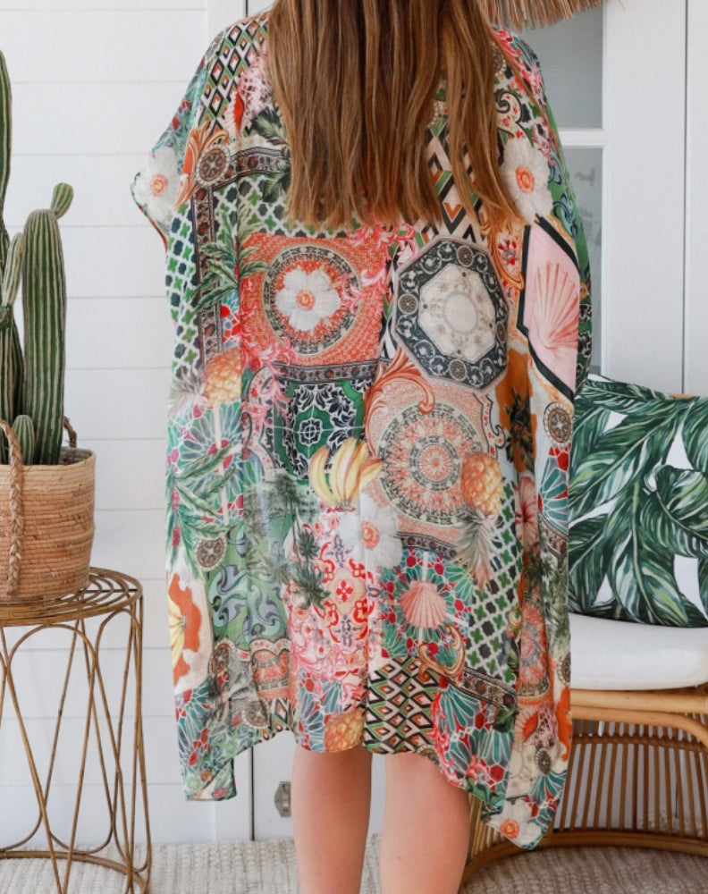 back view of green moroccan print kimono with a woman standing on a boho inspired verandah