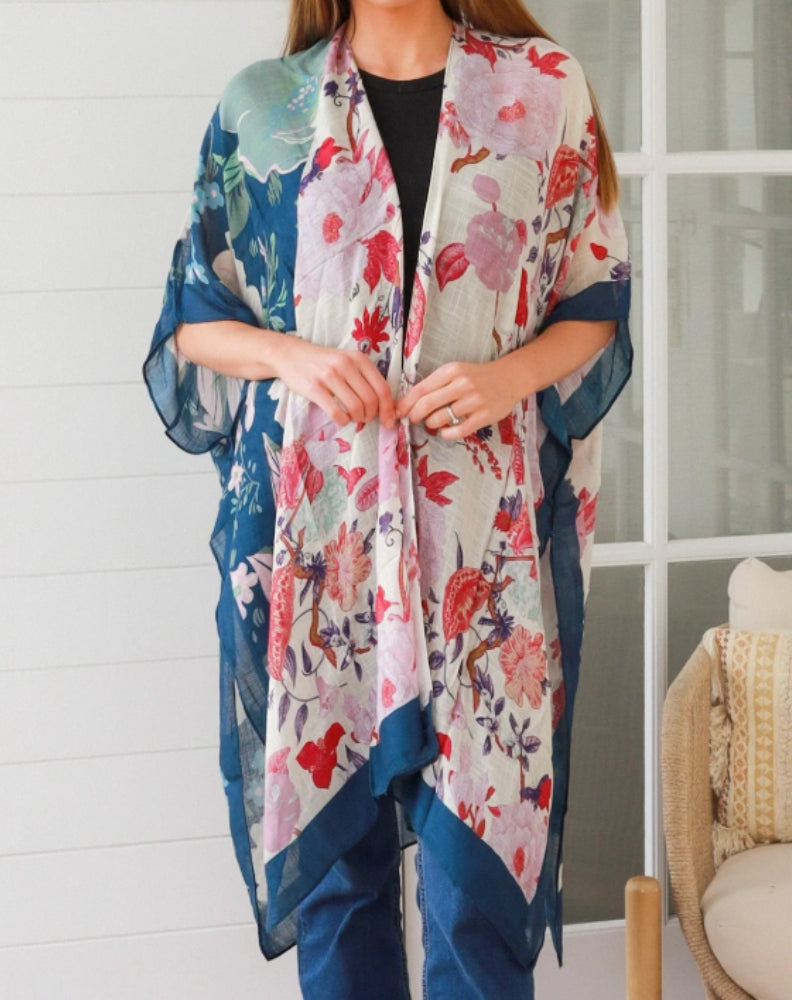 Woman wearing a colorful floral kimono-style garment with a white background