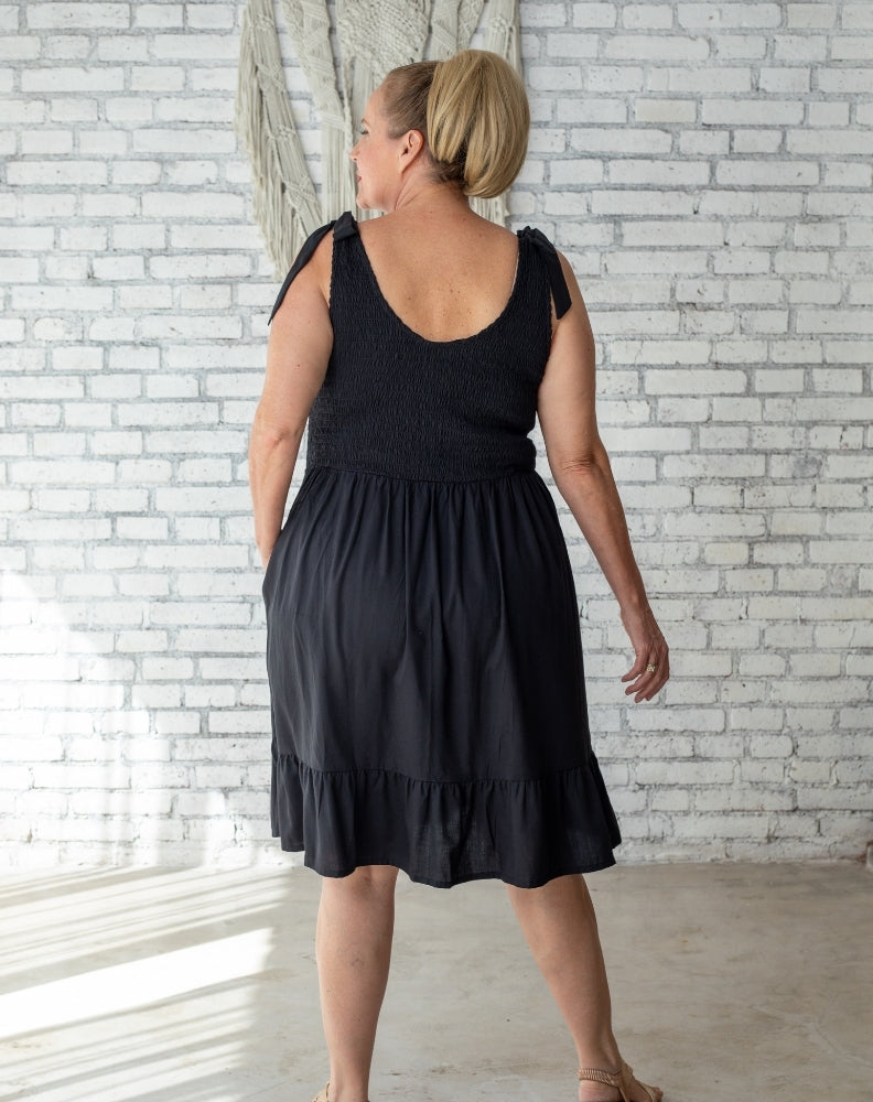 size 16 woman in black shirred knee length dress at a Bali villa