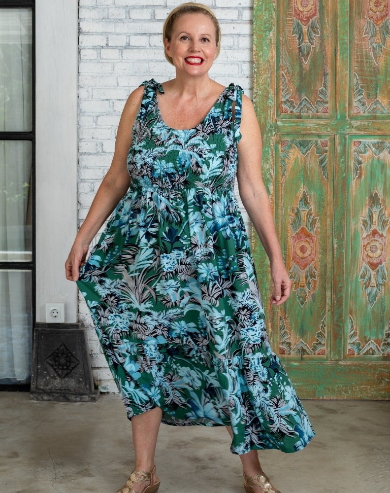 Mature woman wearing a sundress maxi dress standing in front of a Balinese resort villa
