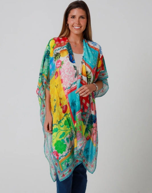 Woman wearing a colourful holiday vibe kimono against a plain background