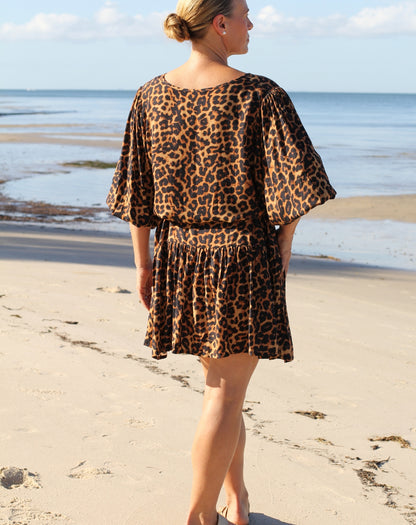 Woman wearing a beach boho leopard print dress looking out to the ocean
