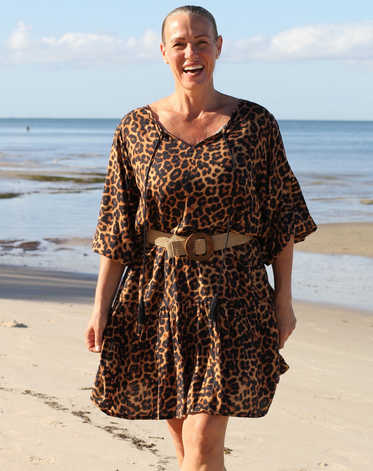 Woman wearing a beach boho leopard print dress on a beach