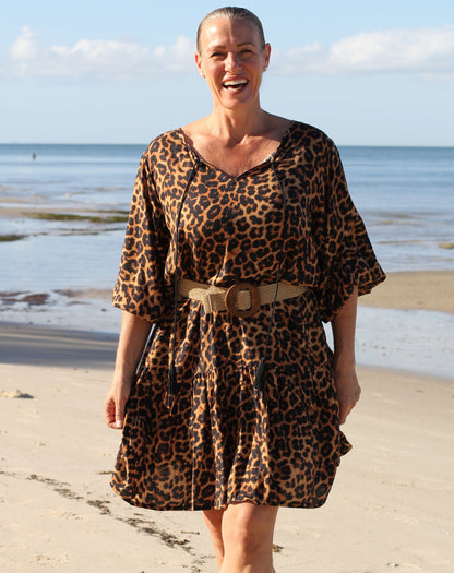 Woman wearing a beach boho leopard print dress on a beach