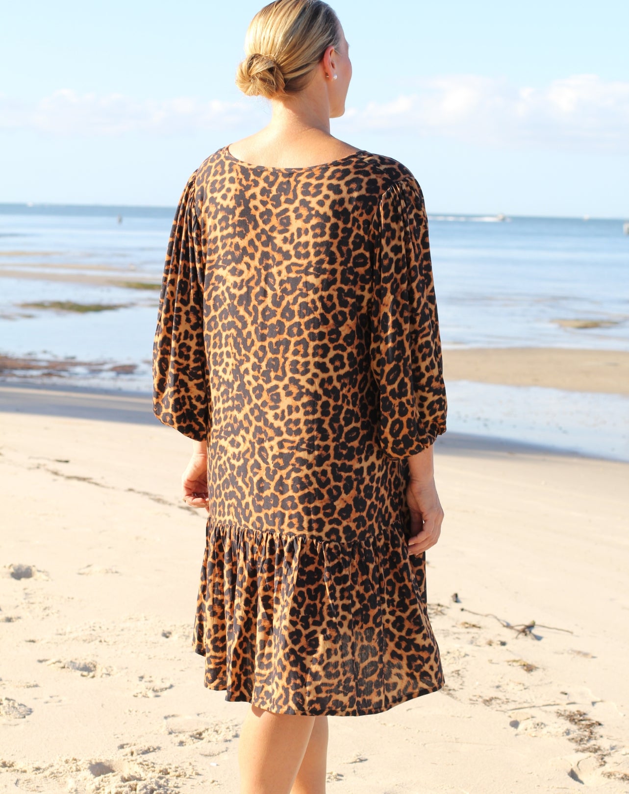Person wearing a leopard print dress on a beach