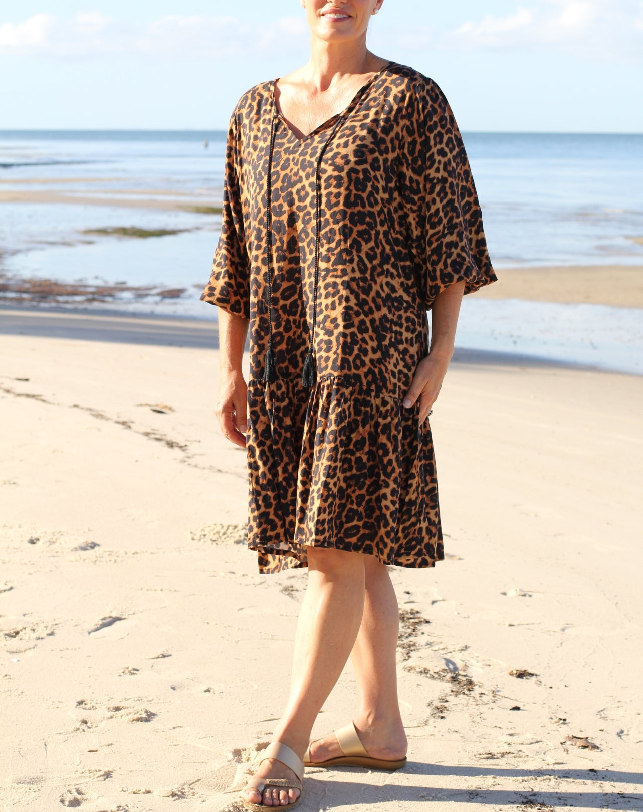 Person wearing a leopard print dress on a beach