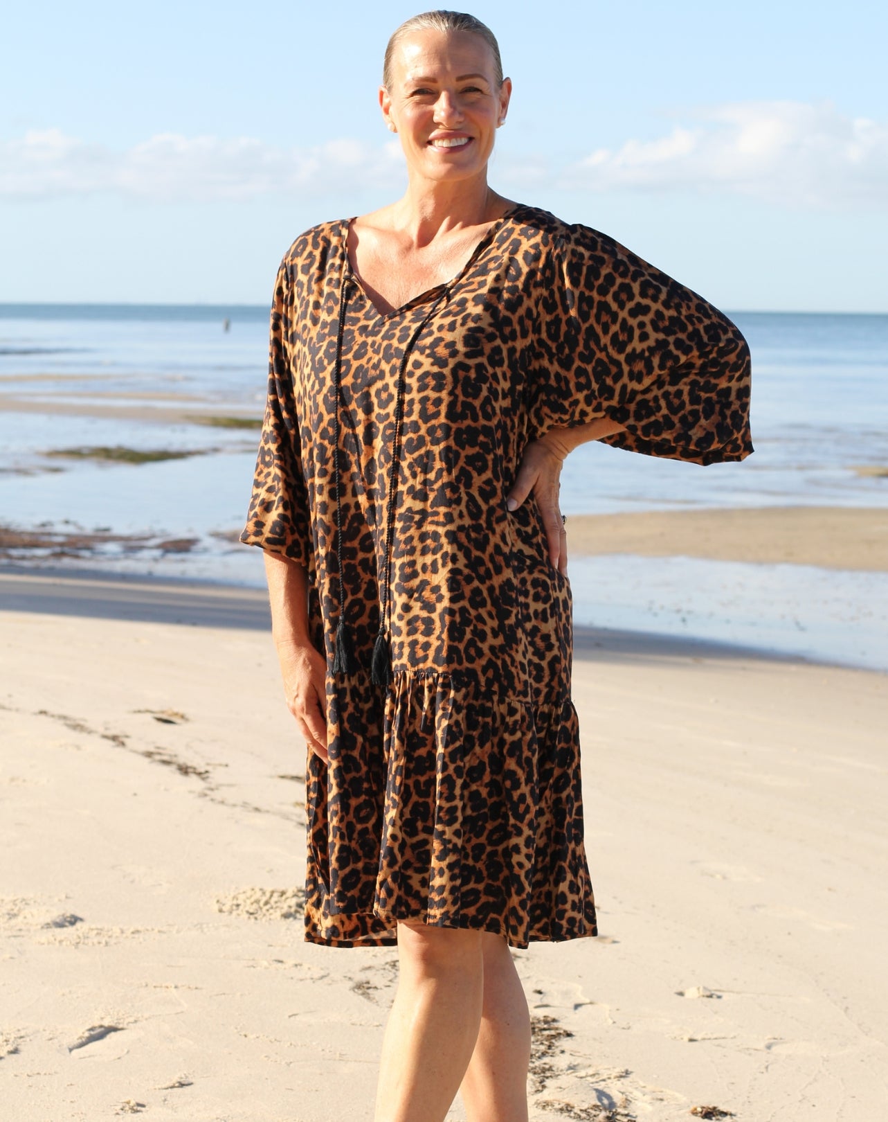 Woman wearing a beach boho leopard print dress on a beach