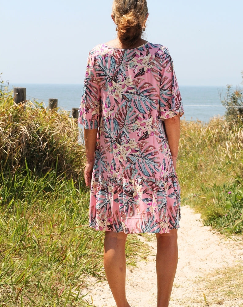 size 12 model wearing sm boho flutter dress in pink topics at beach