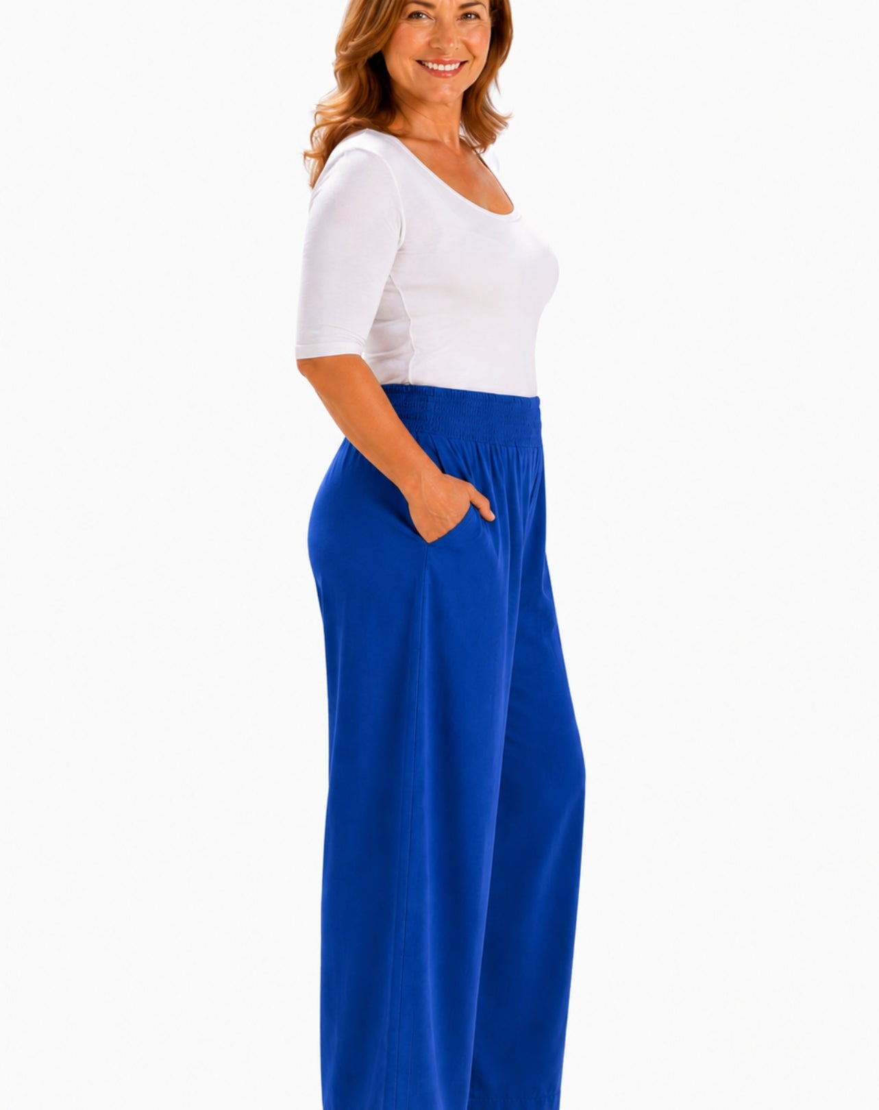 A woman wearing a white short-sleeve scoop-neck top and bright cobolt blue wide-leg pants with side pockets, shown against a plain white background.