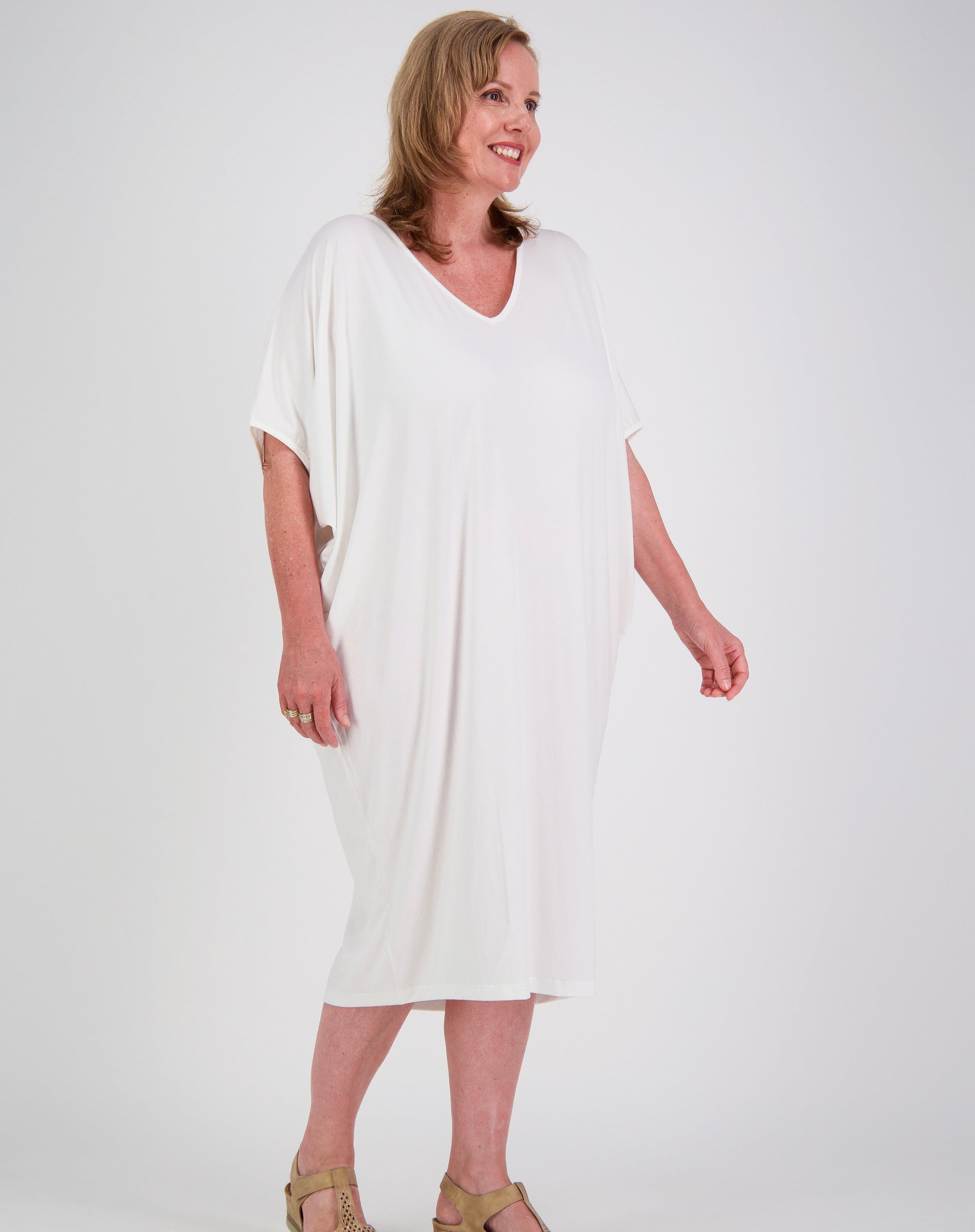 Woman wearing a white modal comfort dress by miss seafari against a plain background