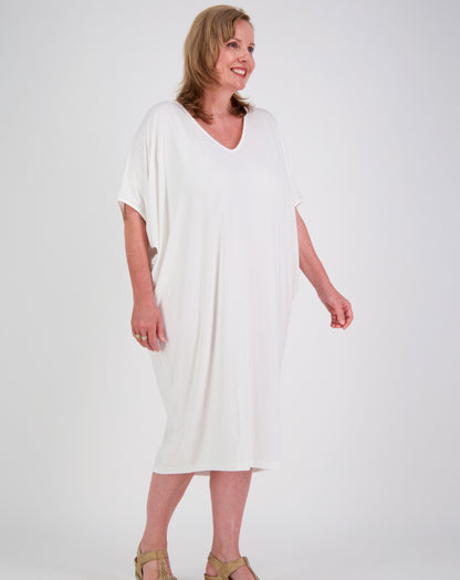 Woman wearing a white modal comfort dress by miss seafari against a plain background