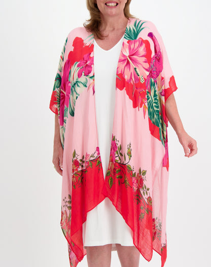 Woman wearing a floral kimono over a white comfort dress  in one size on a white background