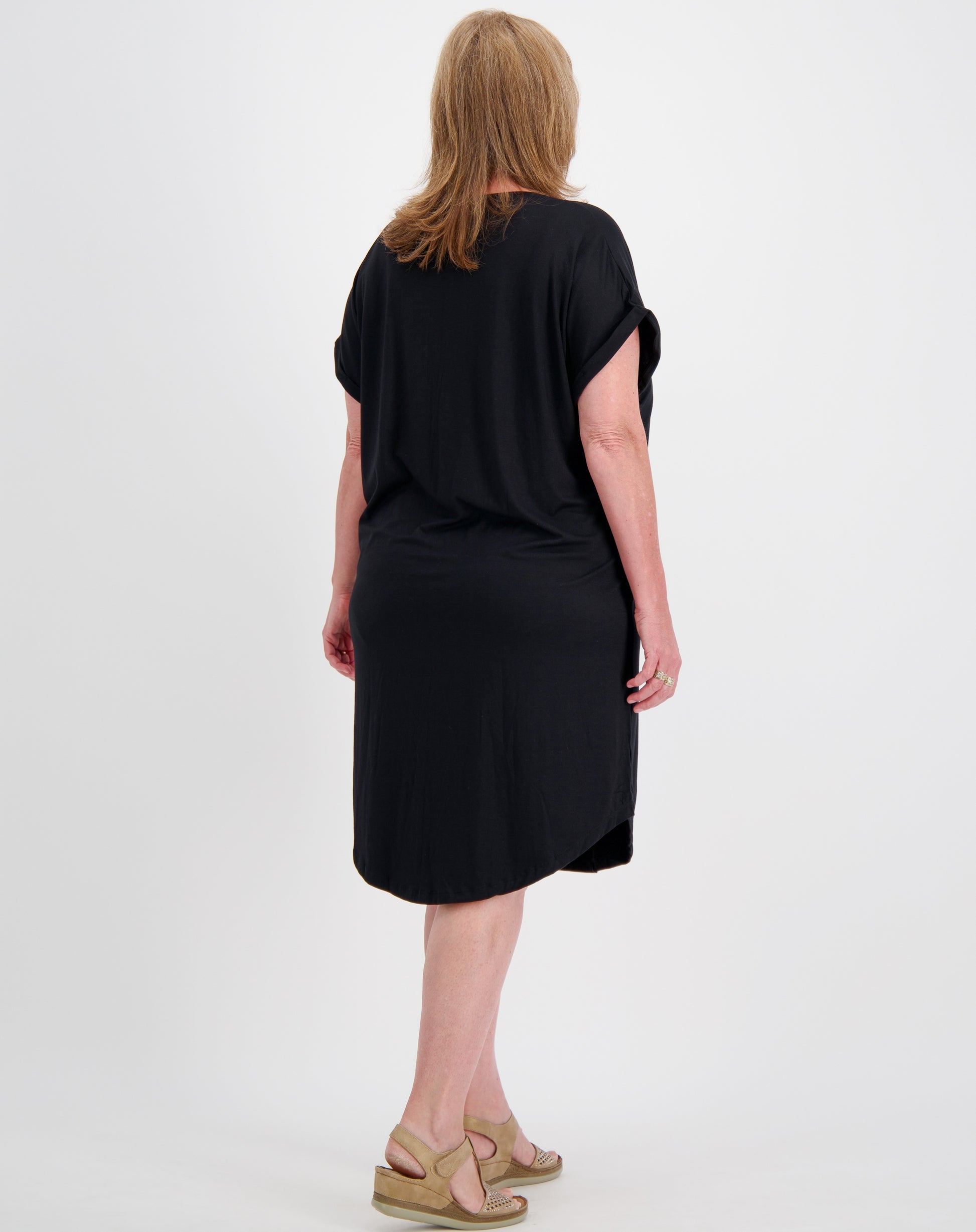 Woman wearing a black dress showing back of dress with curved hem