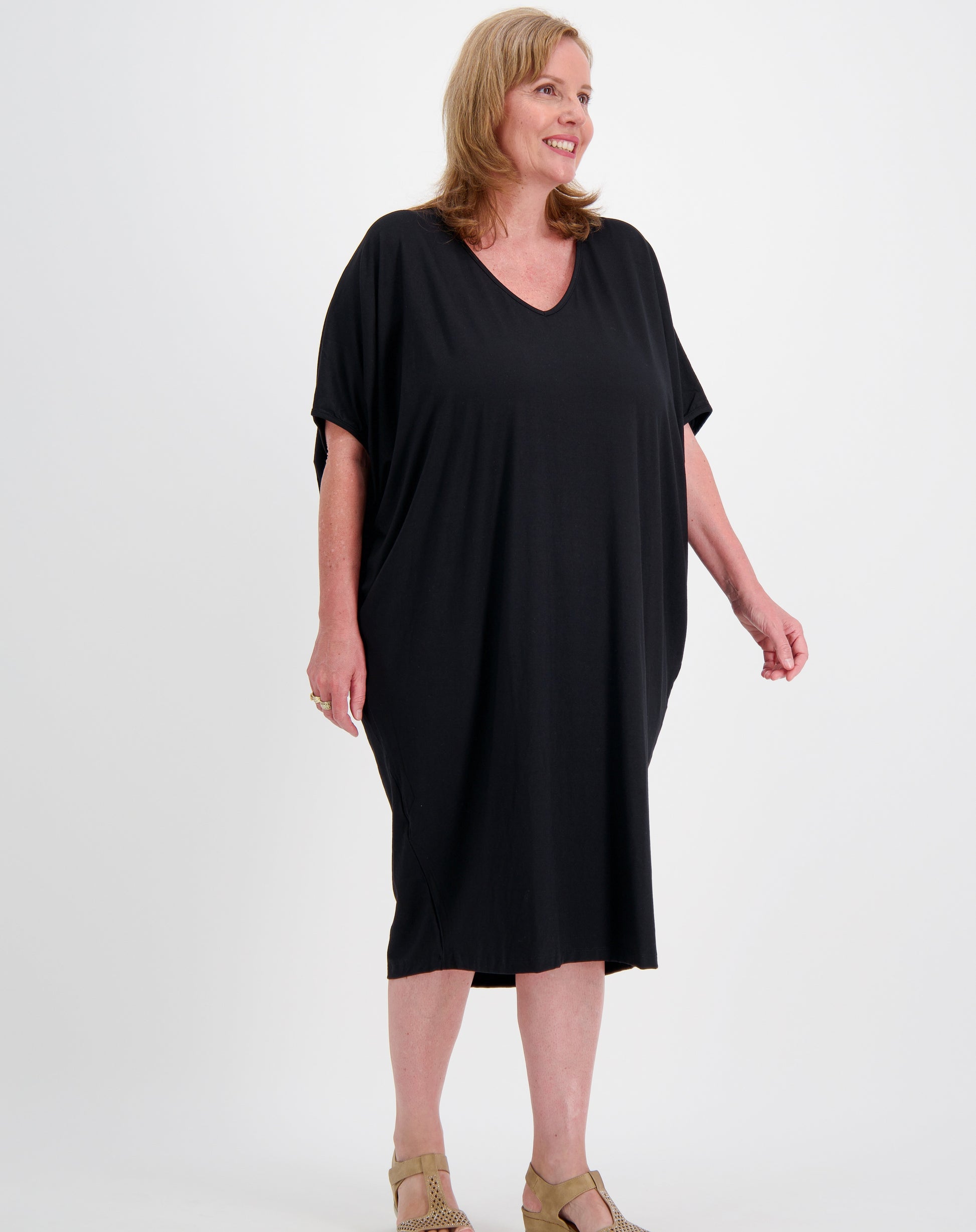 Woman wearing a black one size comfort dress in black modal on a white background