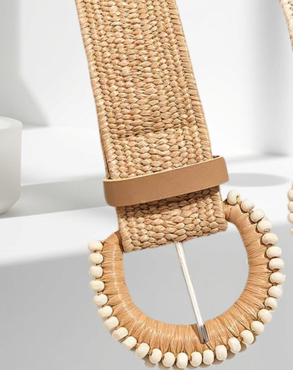 Woven belt with a decorative wooden buckle on a light background