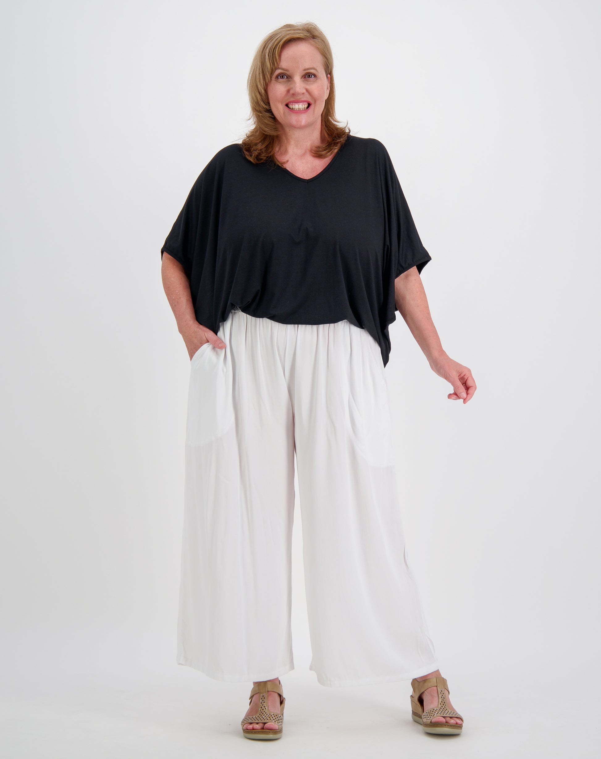 Woman wearing a black modal top and white pants every day pant by miss seafari on a white background