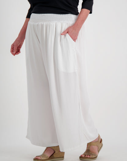 Person wearing white wide-leg pants on a plain background