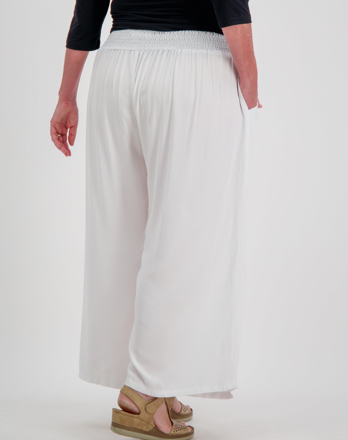 Person wearing white everday pant with wide-leg pants on a plain background