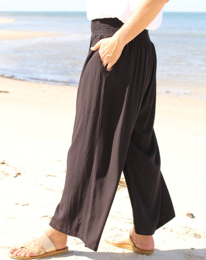 Person wearing every day pant in black  pants on a beach