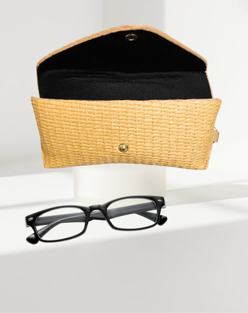 rattan eyeglass case with black interior and a pair of black eyeglasses on a white surface.