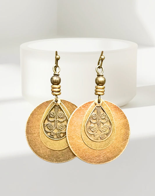 Gold earrings with boho antique designs on a white background