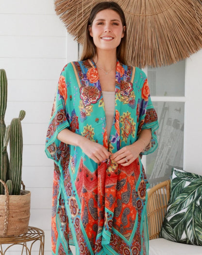 Woman wearing aqua camilla kimono standing indoors in a boho garden setting