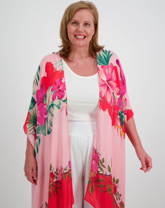 Woman wearing a toucan bird floral kimono by miss seafari over a white outfit on a white background