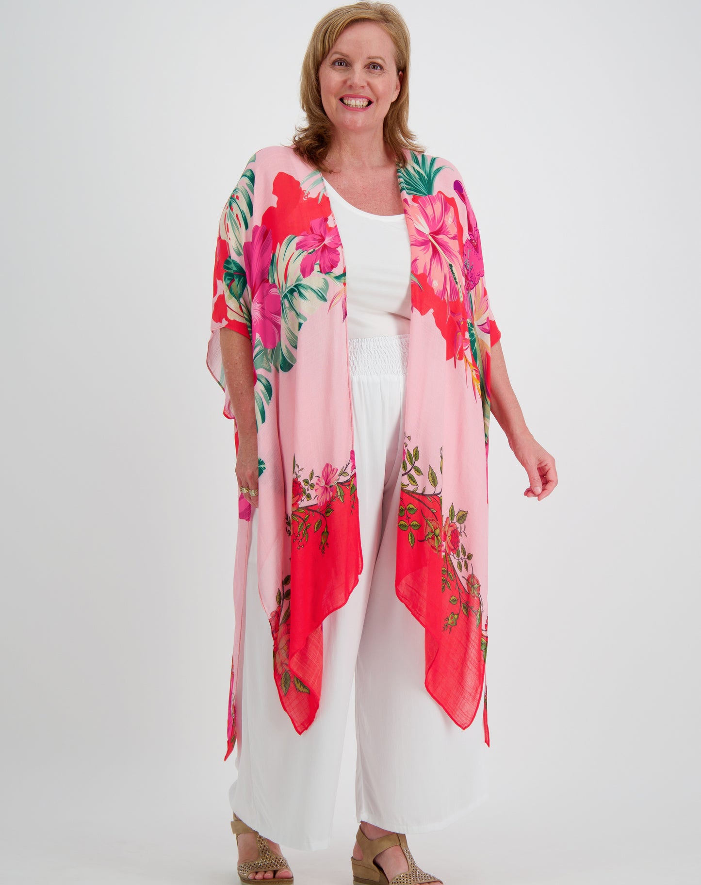 Woman wearing a pink toucan kimono over a white outfit on a white background