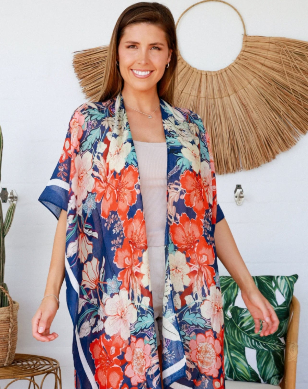 Woman wearing a colorful floral kimono in a home setting with decorative elements.