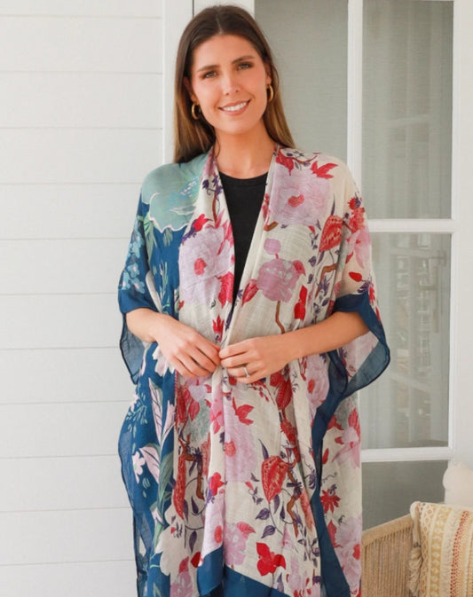 Woman wearing a floral kimono-style jacket indoors.