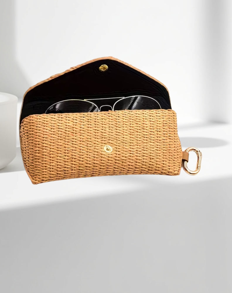 Rattan woven sunglasses case with gold accents on a white background