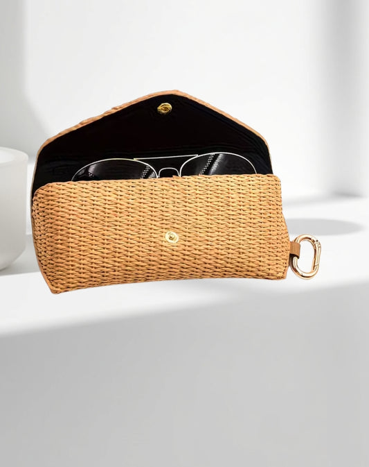 Rattan woven sunglasses case with gold accents on a white background