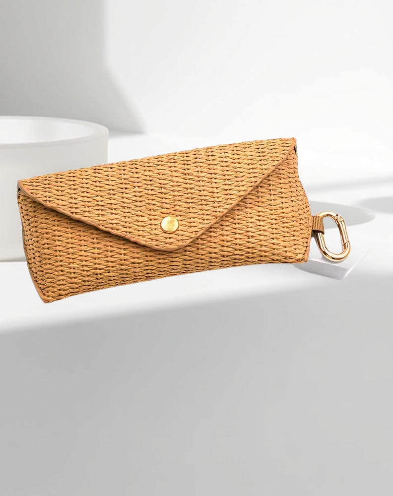 Woven clutch case for glasses with a gold clasp on a light grey background