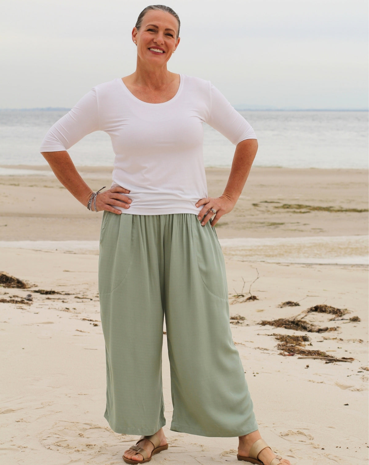 a woman wearing a white scoop tee in modal fabric with beach resort style pant in mint colour at overlooking beach at Moreton Bay