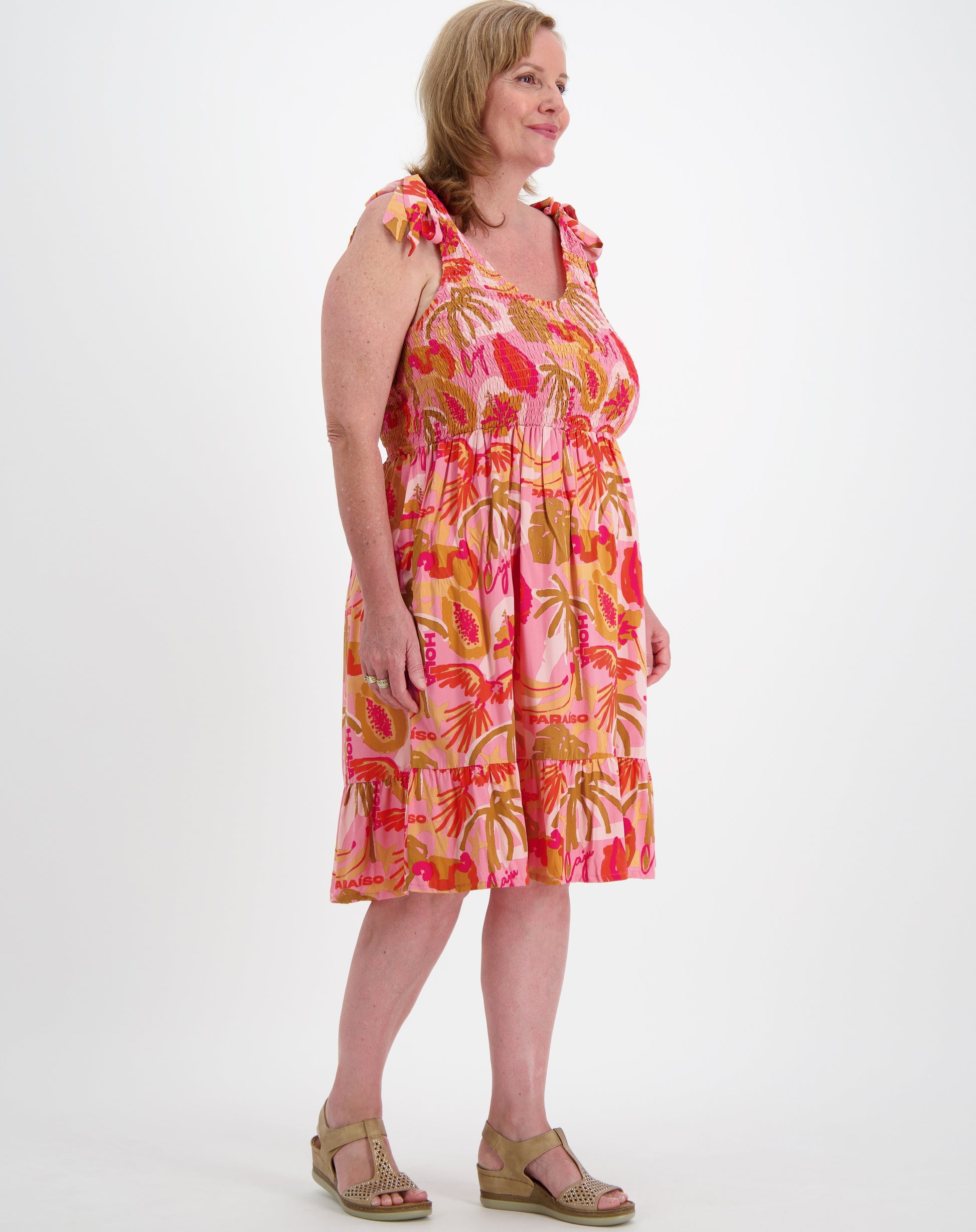Size 16 woman woman wearing a shirred sundress by miss seafari on a white background