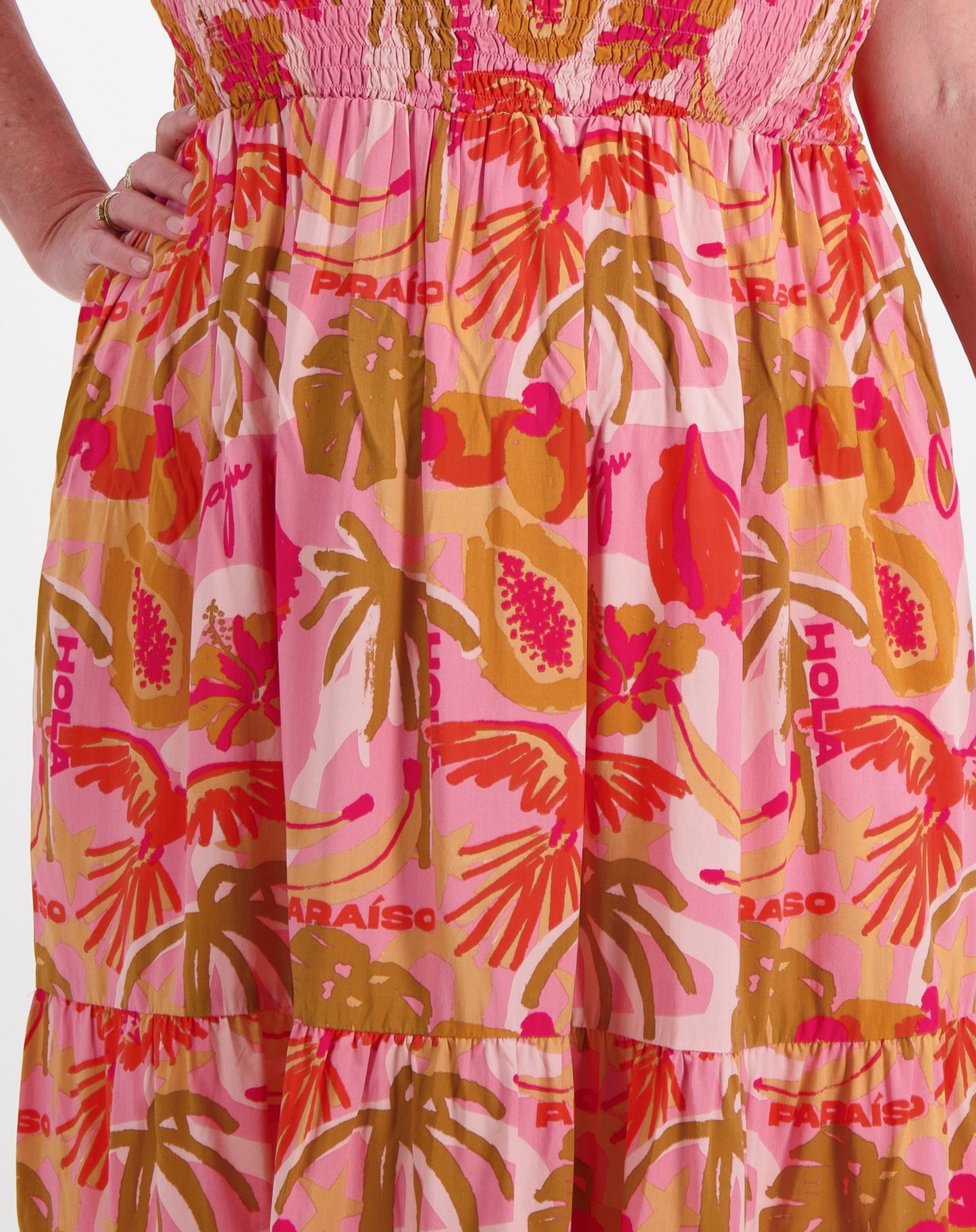 Pink  shirred sundress with orange floral pattern and 'Paraiso' text on a white backgroud